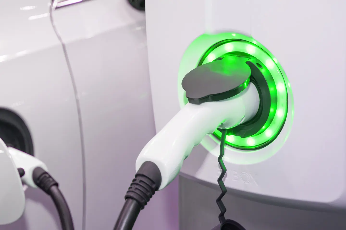 close up of green electric car charger plugged in