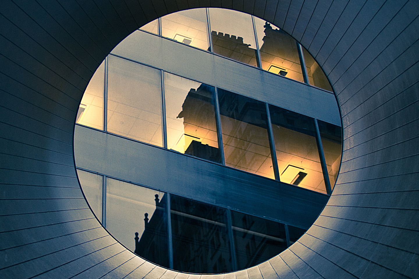 reflection on high rise building windows through a tube