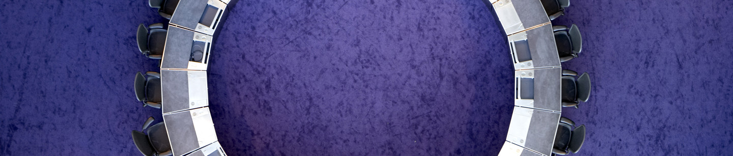 Aerial view of circular table with surrounding chairs and purple floor