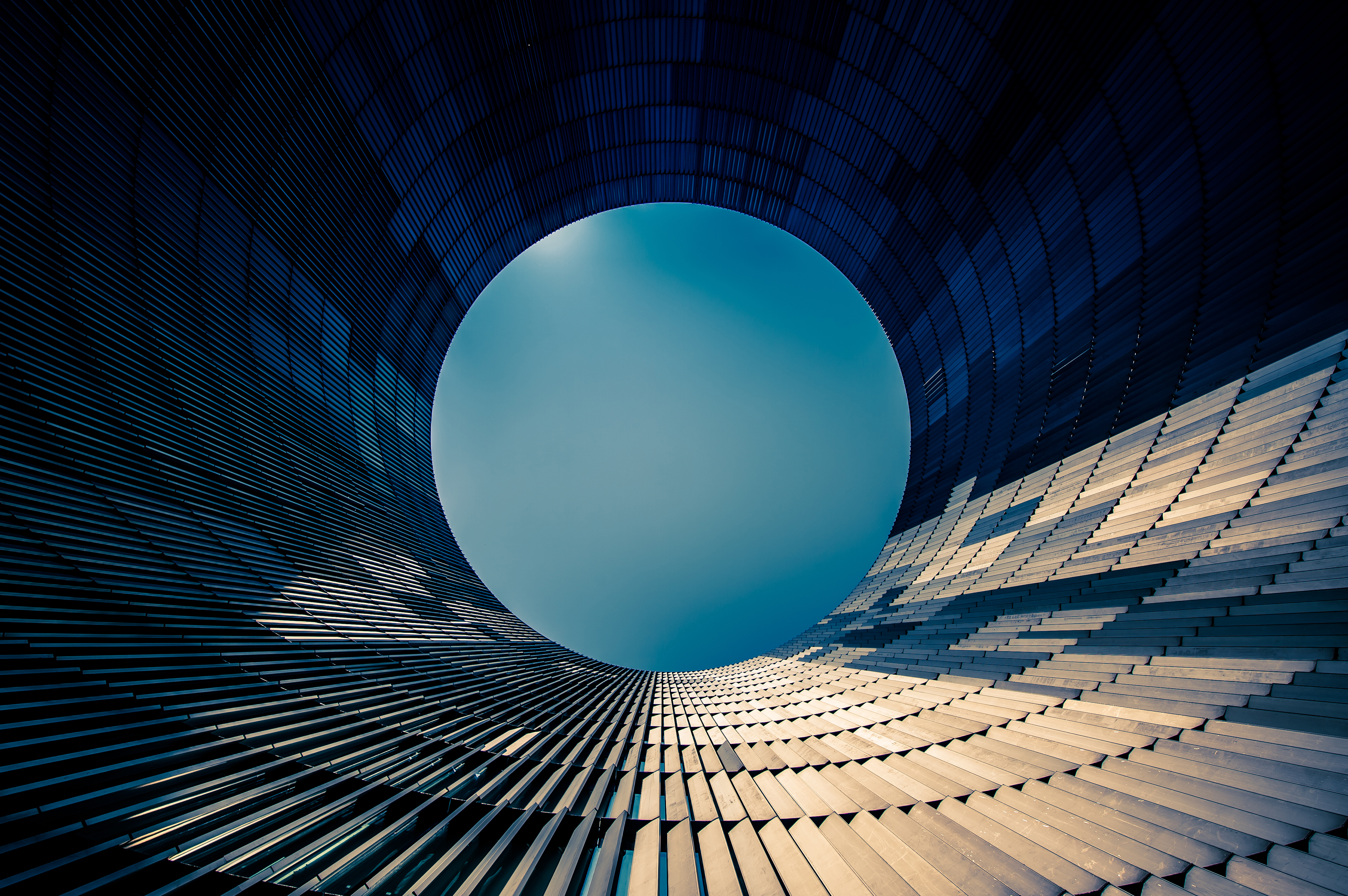 Circular engineered building pointing up towards sky